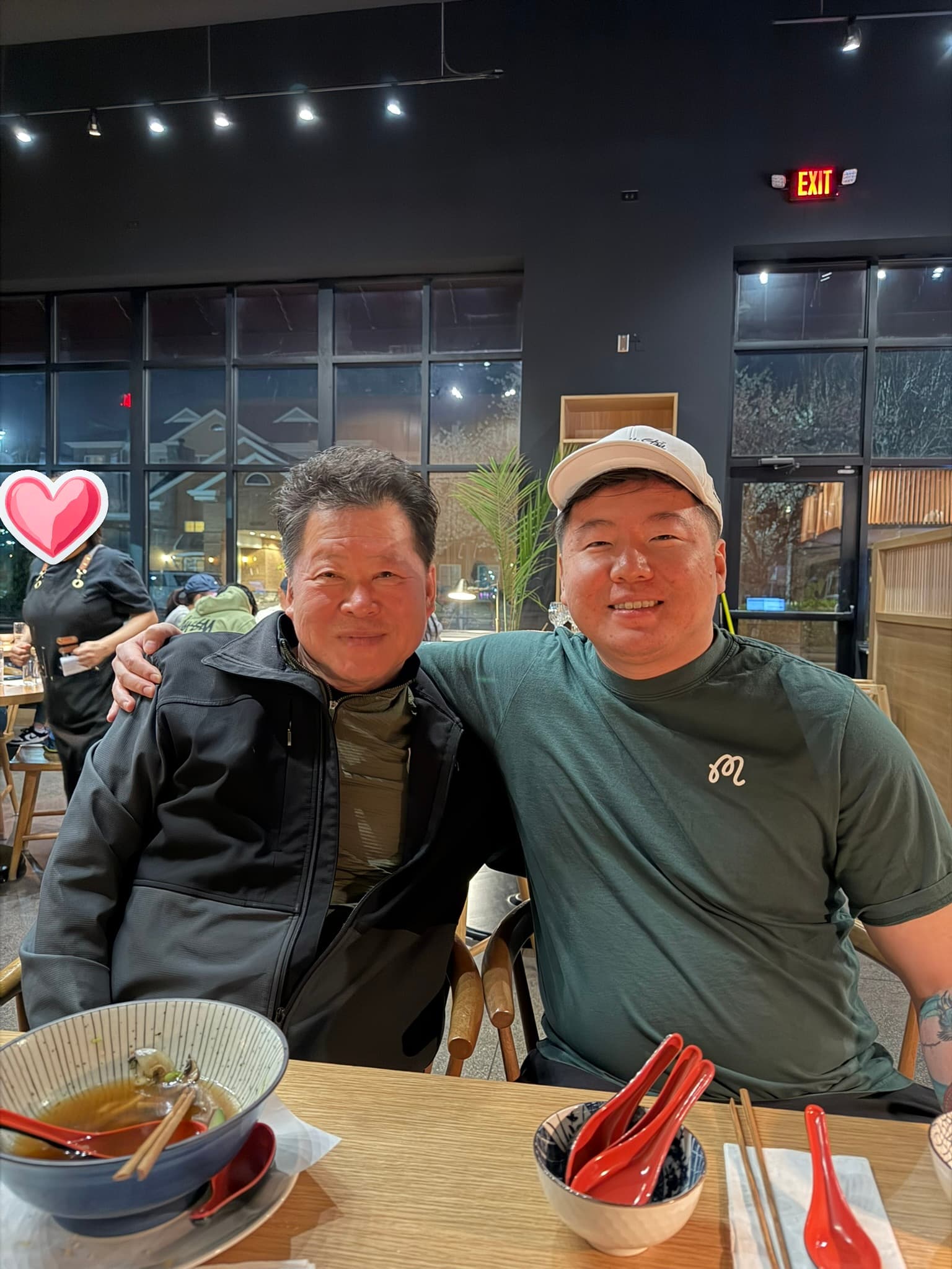 Daniel and his dad, arms around each other at dinner